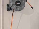 a hose attached to a wall with an orange cord