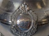 a silver plate with a silver lid on a table