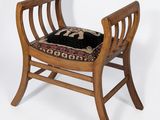 a small wooden chair with a black cushion on it