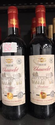 plusieurs bouteilles de vin sont alignées sur une étagère dans un magasin