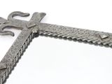 a metal cross with a chain around it on a white surface