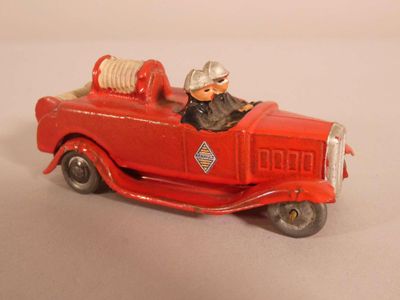 un camion de pompiers rouge en jouet avec un homme à l'intérieur