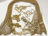 de nombreux colliers et bracelets en or posés sur un fond blanc