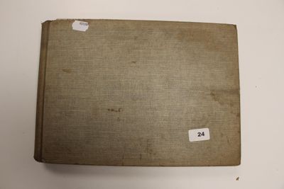 un vieux livre posé sur une table à côté d'un mur blanc