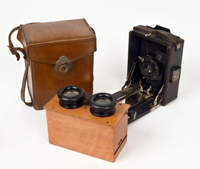 two old cameras sitting next to each other on a white surface