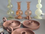 a group of vases and a candle holder on a table