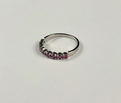 a close up of a silver ring with pink stones on it