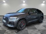 une Audi QX 2021 grise garée dans une grande pièce