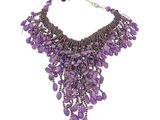 un gros plan d'un collier violet sur fond blanc