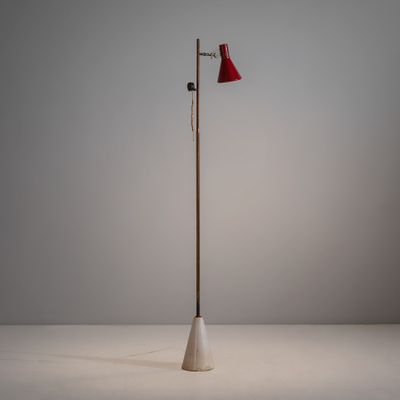 le lampadaire est surmonté d'un abat-jour rouge