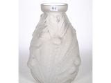un vase blanc posé sur une table à fond blanc