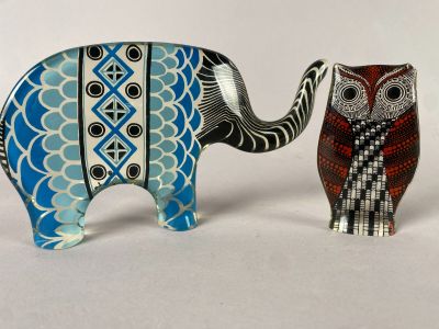 deux figurines représentant un éléphant et un hibou posées sur une table