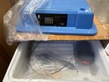 a plastic container with a blue lid sitting on top of a cardboard box