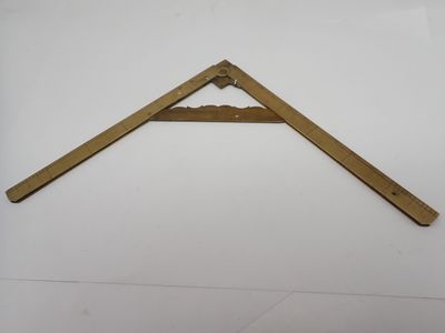 un gros plan d'un triangle en bois posé sur une surface blanche