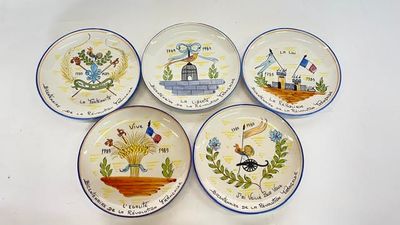 quatre assiettes à motifs différents posées sur une surface blanche