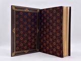 un livre ouvert orné d'un motif floral, posé sur une surface blanche