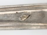 a close up of a silver spoon with a hole in it