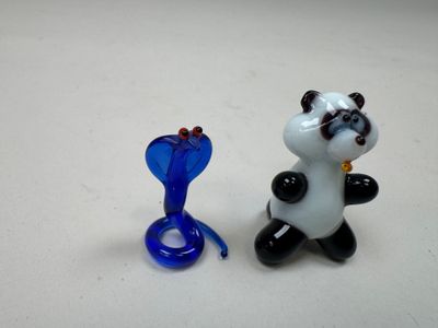 deux figurines en verre représentant des pandas assis l'un à côté de l'autre