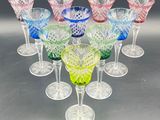 a set of six multicolored wine glasses sitting on top of a table