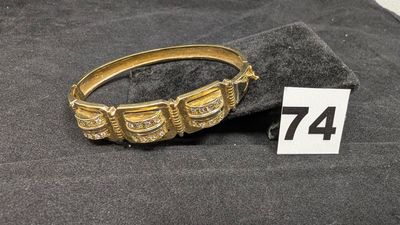 un gros plan d'un bracelet en or posé sur un tissu noir