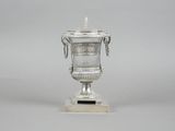 a silver vase that is sitting on a table
