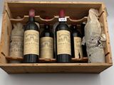 trois bouteilles de vin dans un coffret en bois sur lequel est apposée une étiquette de prix