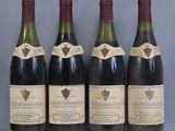 four bottles of wine are lined up on a table