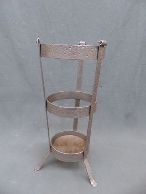 Porte-parapluie en fer forgé gris et cuivre.