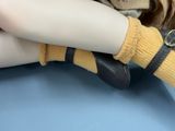 a close up of a doll wearing a pair of shoes
