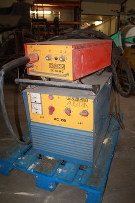 two welding machines sitting on top of each other in a garage