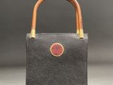 a black leather bag with a wooden handle and a wooden handle