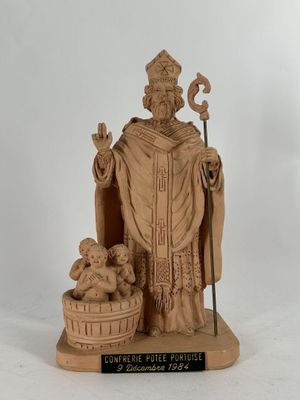 une statue représentant un homme tenant un bébé et un panier de cerises