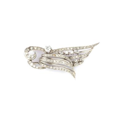 un gros plan d'une broche en forme d'oiseau dont les ailes sont ornées de diamants