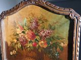 a mirror with a painting of flowers on it in a room