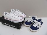 une paire de Converse blanches et bleues posées sur une boîte
