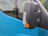 an image of a side view mirror of a blue van