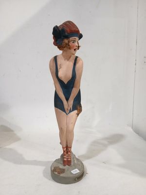 a figurine of a woman in a bathing suit on a pedestal