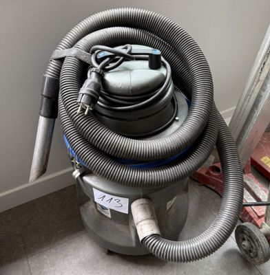 un aspirateur posé sur le sol à côté d'un mur