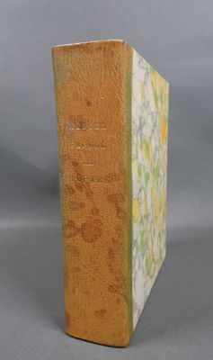 un vieux livre posé sur une table en bois devant un fond gris