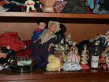 many dolls on a shelf in a cabinet
