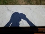 l'ombre d'une personne tenant un appareil photo posé sur une table