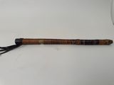 a close up of a wooden stick with a tassel on top of it