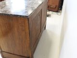 a wooden cabinet with a marble top in a room