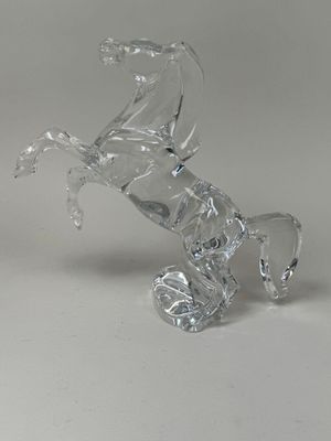un cheval en verre assis sur ses pattes arrière