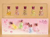 five miniature bottles of perfume in a clear display case