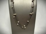 a close up of a necklace with pearls on a mannequin