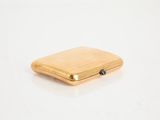 an image of a gold cigarette case on a white surface