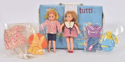 deux poupées assises à côté d'une valise