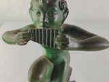 statue of a boy with a flute in his hands on a black base