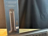 une photo d'un radiateur soufflant noir posé sur une table en bois